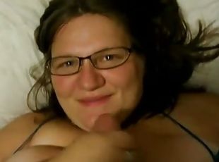 Chubby brunette wearing glasses milks a cock dry on her face