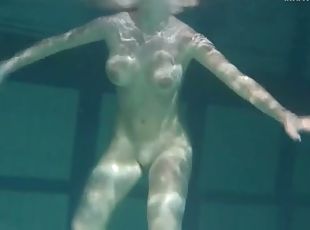 Naked brunette with big tits swims solo