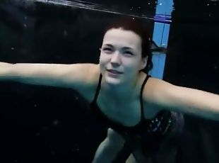 Beautiful girl swims and smiles underwater