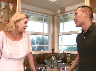 Tattooed Asian dude fucks a hot blonde milf in the kitchen