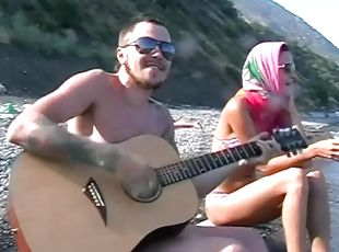 He plays guitar for her and fucks her on the beach