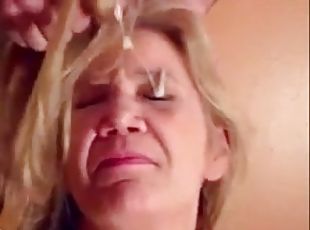 Blonde granny is taking a cumshot on her eyes